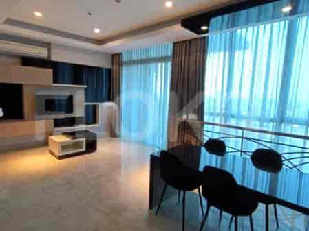 A modern living and dining area with a large window overlooking a city view, featuring a dining table with chairs and a media console.