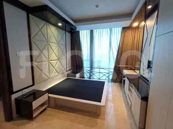 A luxurious bedroom featuring a queen-sized bed with a patterned headboard, a nightstand, and a built-in vanity area.