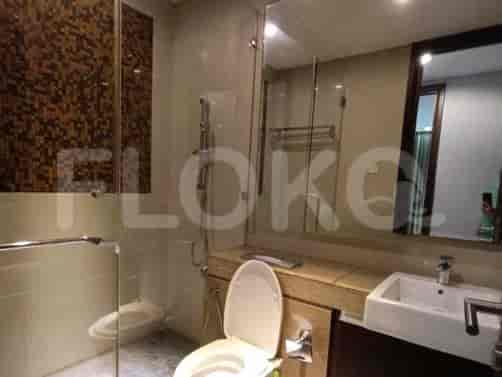 A modern bathroom with a glass shower enclosure, a toilet, and a vanity with a mirror.