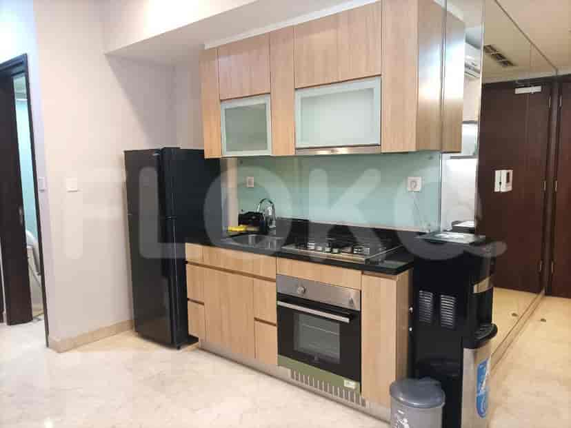 Modern kitchen featuring overhead cabinets, a countertop with a stove, and a refrigerator.