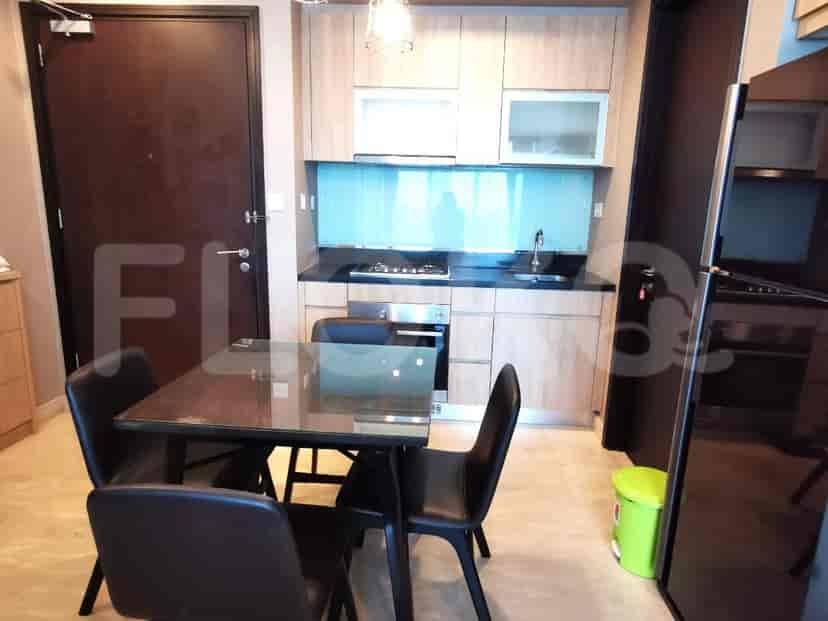 A compact kitchen featuring cabinets, a stove, and a dining area.