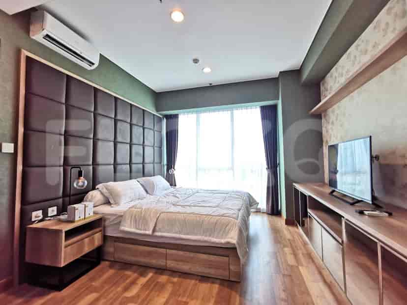 Bedroom with a large bed, wooden floor, and a large window.