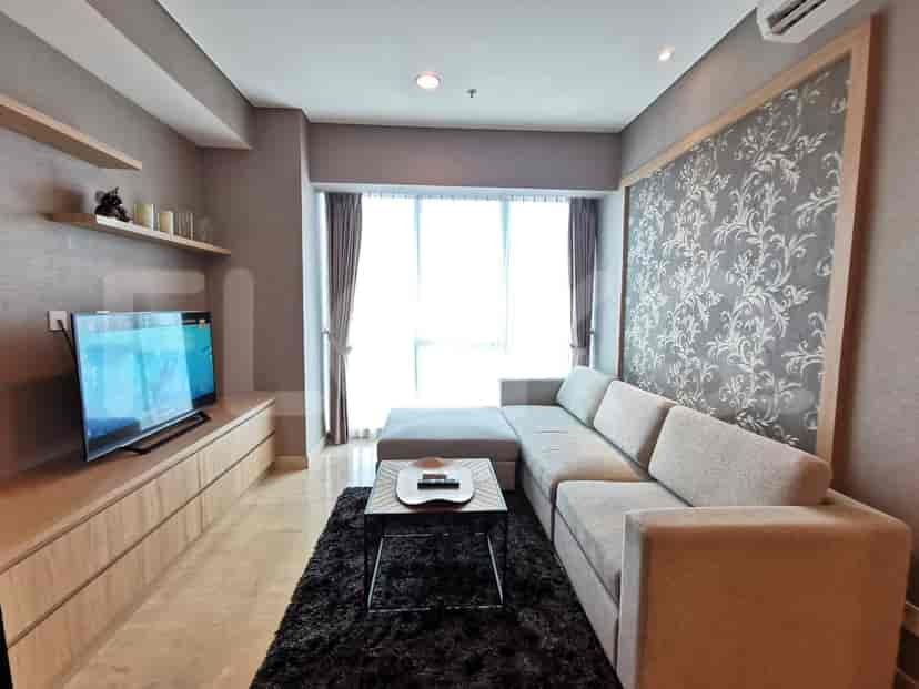 Modern living room featuring a grey L-shaped sofa, a large window, and a mounted TV.