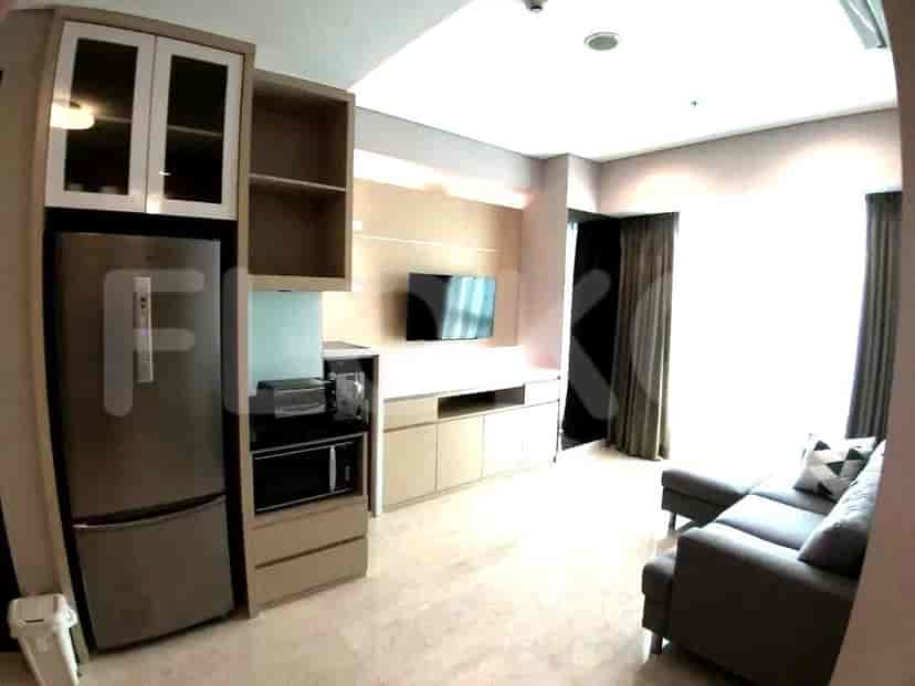 A modern apartment kitchen area with built-in appliances, a refrigerator, and overhead cabinets.