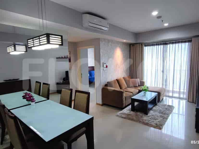 Open concept living and dining area featuring a dining table, brown L-shaped sofa, and access to a balcony.