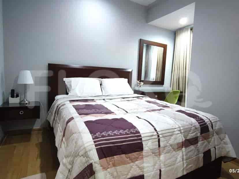 Cozy bedroom with a double bed, wooden furniture, and a large window.