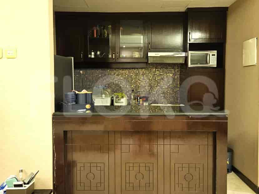 A kitchen setup with dark wooden cabinets and built-in appliances.