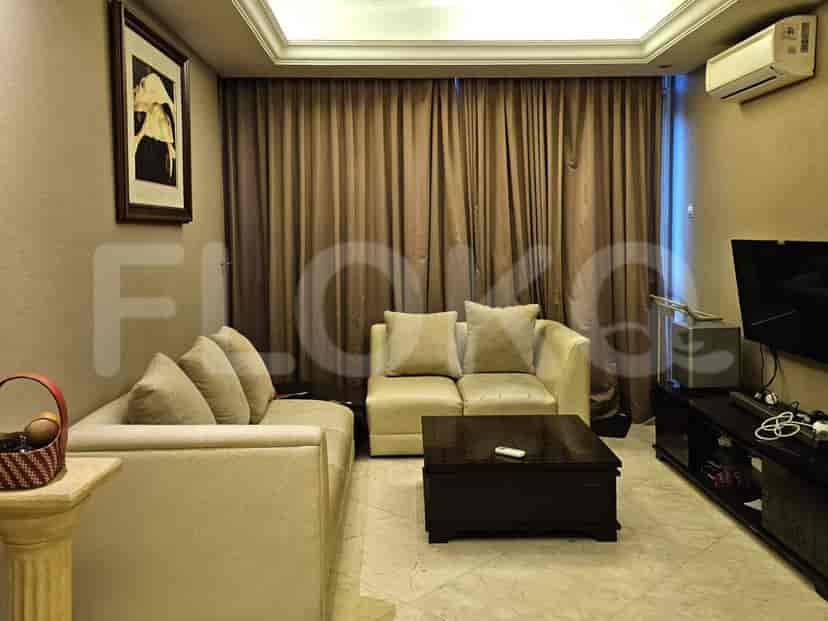 A living room with beige sofas, a wooden coffee table, and a mounted TV.