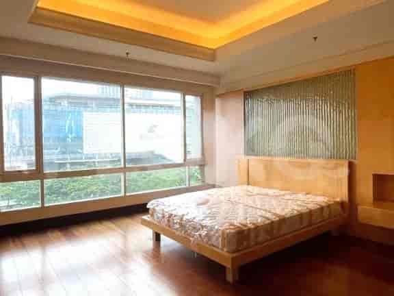 Kamar tidur dengan jendela besar dan tempat tidur.