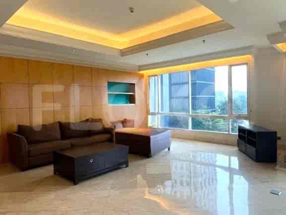 Ruang tamu yang menampilkan sofa coklat, panel kayu, dan pemandangan kota.