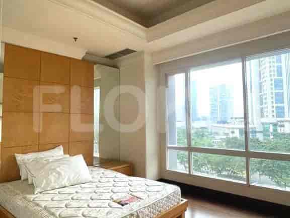 Kamar tidur dengan tempat tidur, headboard besar, dan pemandangan kota.