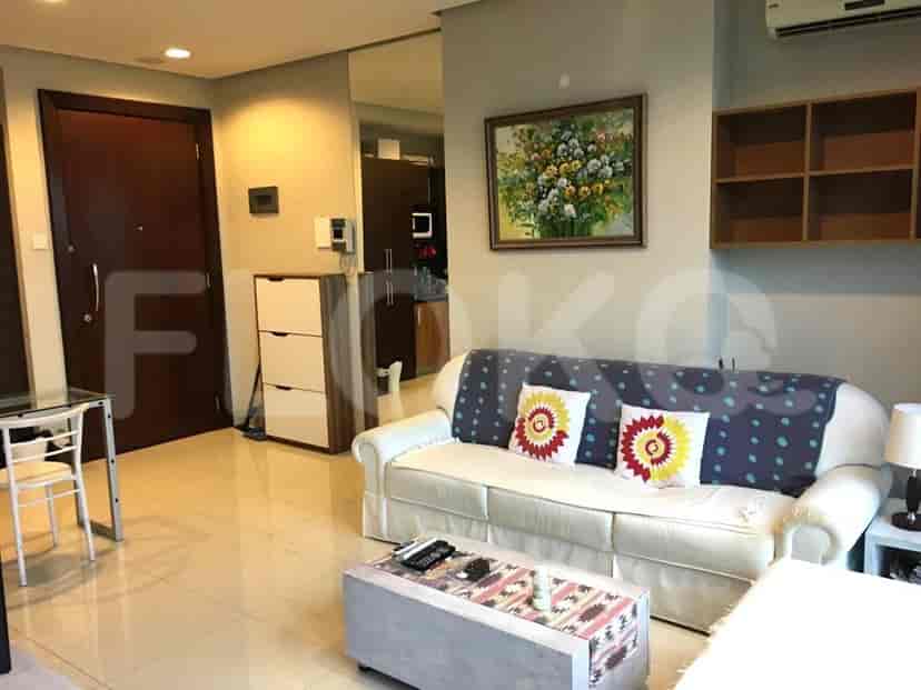 Living room featuring a white sofa with decorative cushions, a coffee table, and artwork.