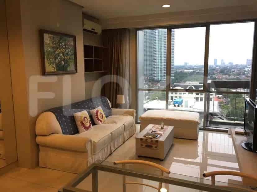 Living room with a sofa, large windows, and a view of the city.