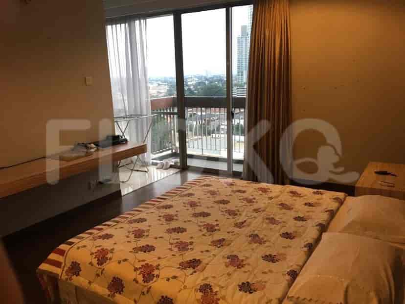 Bedroom with a bed, window, and balcony access.