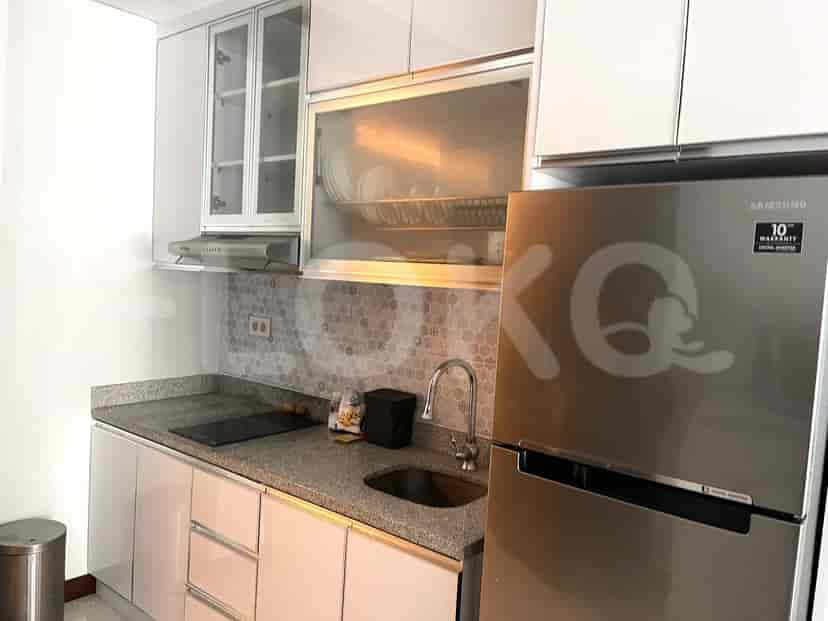 A kitchen with a stainless steel fridge, cabinets, and a sink.