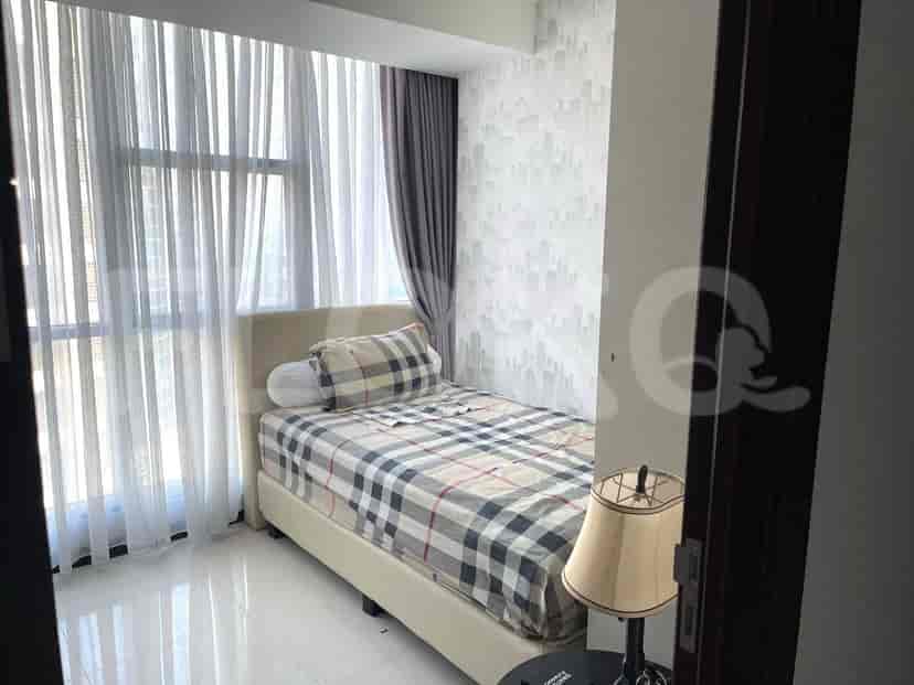 A bedroom with a single bed and patterned bedding.