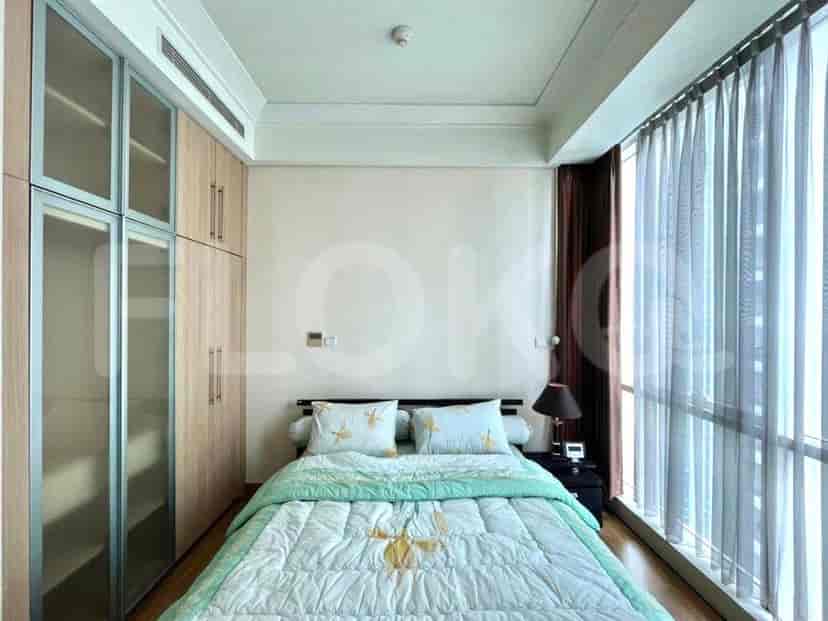 Cozy bedroom with a bed, closet, and large windows.