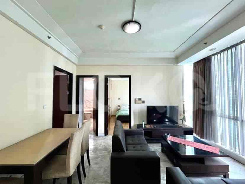 Open-plan living space showcasing a dining area, living room, and hallway leading to a bedroom.