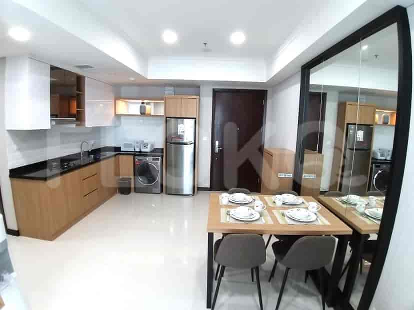 Dapur terbuka dengan area makan, menampilkan peralatan modern dan lemari kayu.