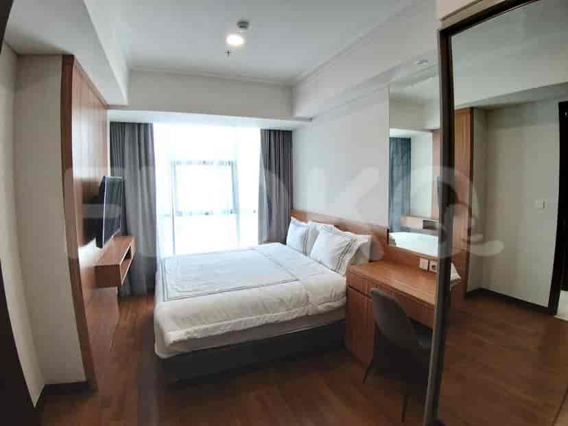 Kamar tidur dengan tempat tidur, meja belajar, dan lantai kayu.
