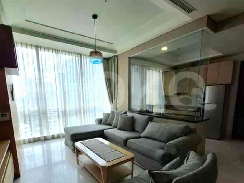 Living room with grey sectional sofa, coffee table, and large window with sheer curtains.