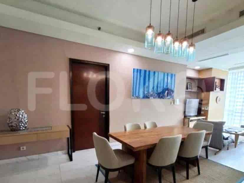 Dining area with wooden dining table, chairs, and a decorative wall painting.