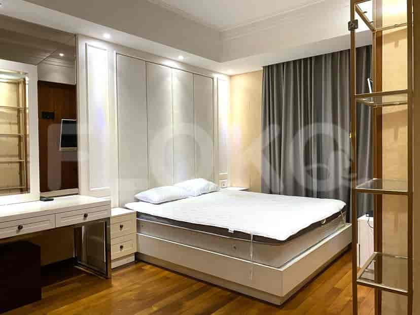 Elegant bedroom with a large bed, vanity, and curtains.