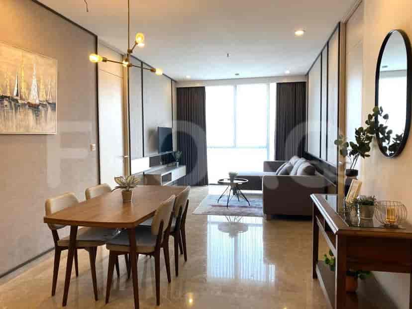 Area ruang tamu dan makan terbuka dengan meja makan, sofa, dan pencahayaan dekoratif.