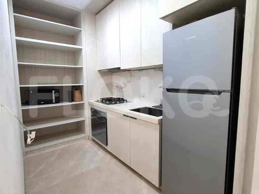 Dapur modern dengan lemari kayu, peralatan built-in, dan meja marmer.