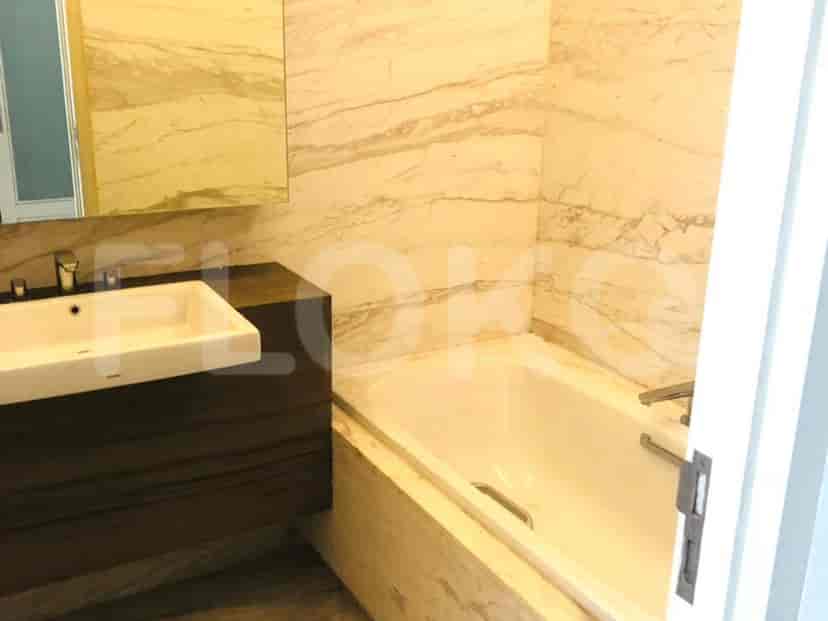 Kamar mandi dengan bak mandi, wastafel, dan cermin.
