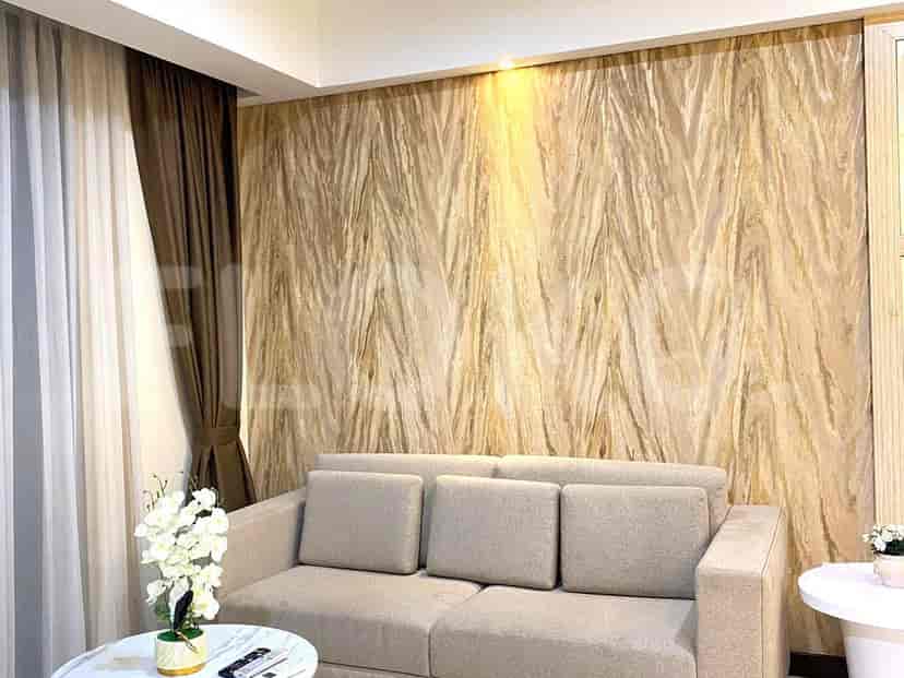 Ruang tamu yang menampilkan sofa krem, wallpaper bermotif, dan meja kopi bundar.