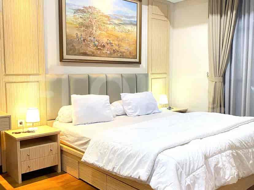 Kamar tidur dengan tempat tidur, meja samping tempat tidur, dan karya seni.