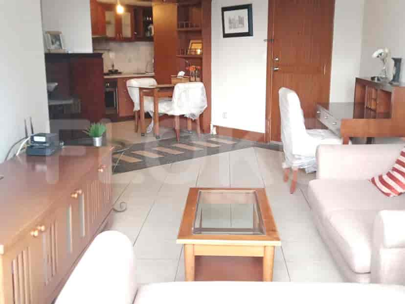 Living room featuring wooden furniture, a sofa, and a view into the kitchen.