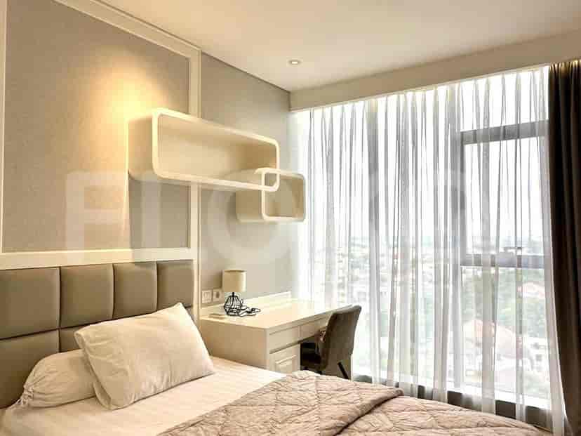 Bedroom featuring a desk, floating shelves, and large windows with sheer curtains.