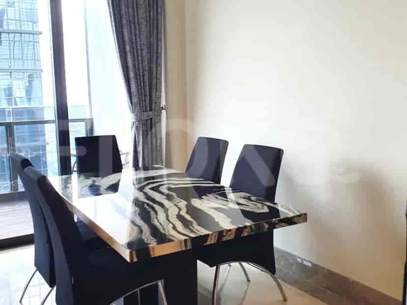 Area makan dengan meja marmer dan kursi hitam.