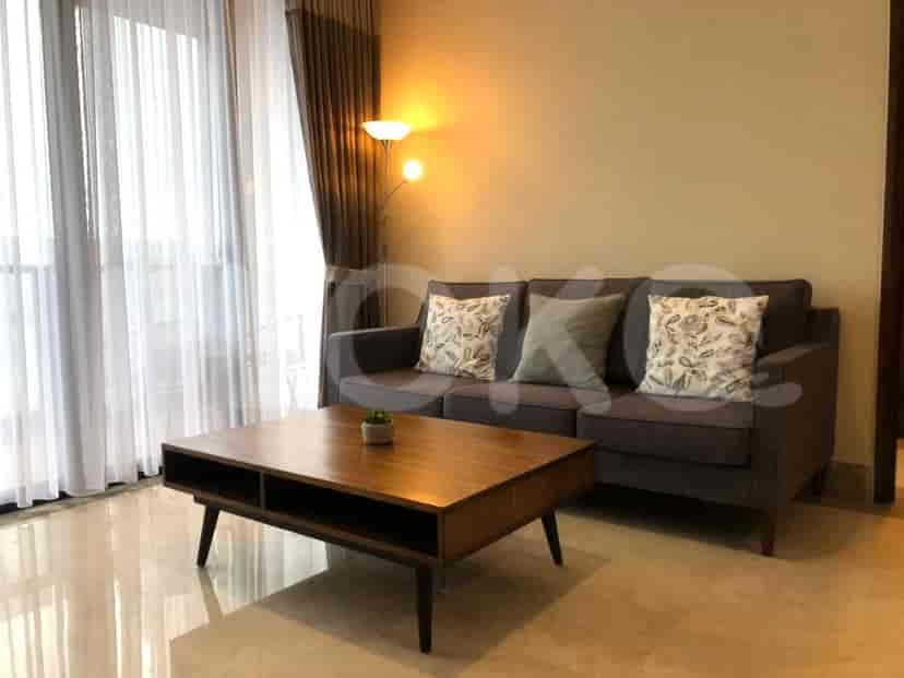 Living room with a sofa, coffee table, and large windows.