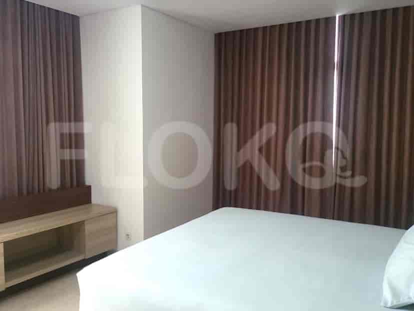 A bedroom with a large bed and brown curtains.