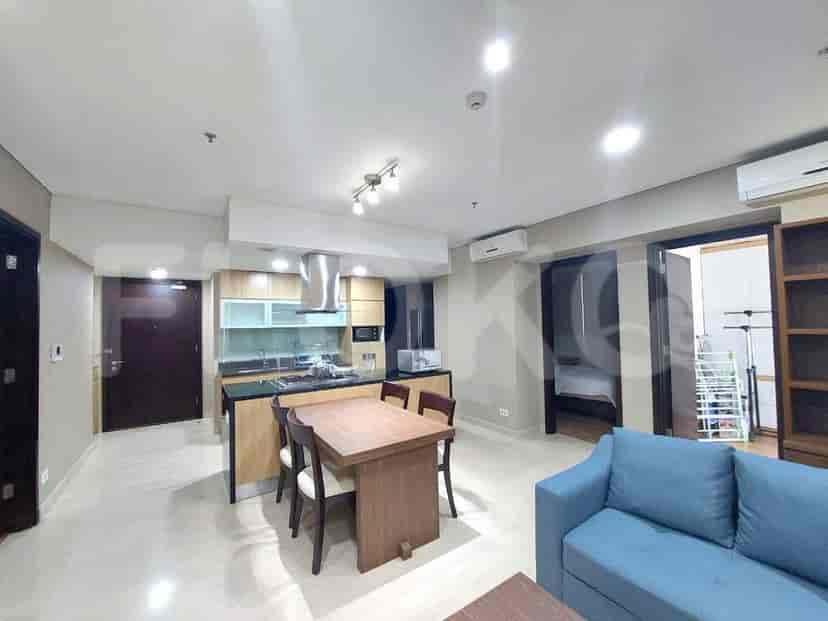 A combined living room and kitchen space with a dining area, blue sofa, and modern kitchen design.