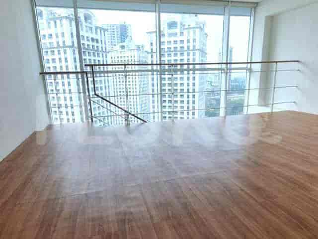 A loft area with large windows, wooden flooring, and a minimalist design.