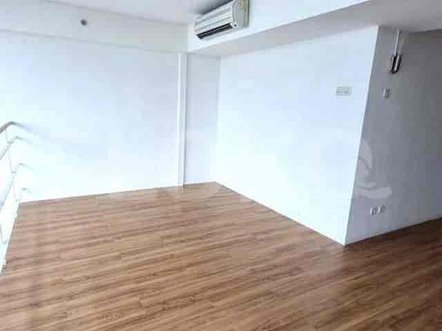 A loft space showing white walls, wooden flooring, and an air conditioning unit.