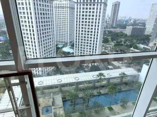 View from the window showing buildings, a pool area and trees.