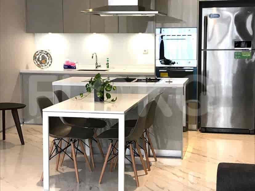 Modern kitchen with a cooking island, refrigerator, and cabinets.