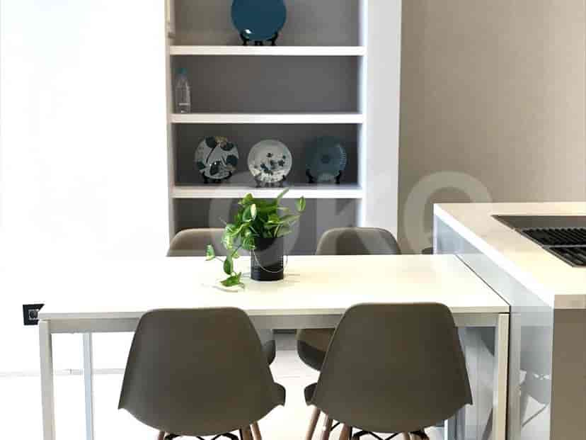Dining area with a white table, chairs, and shelving unit.