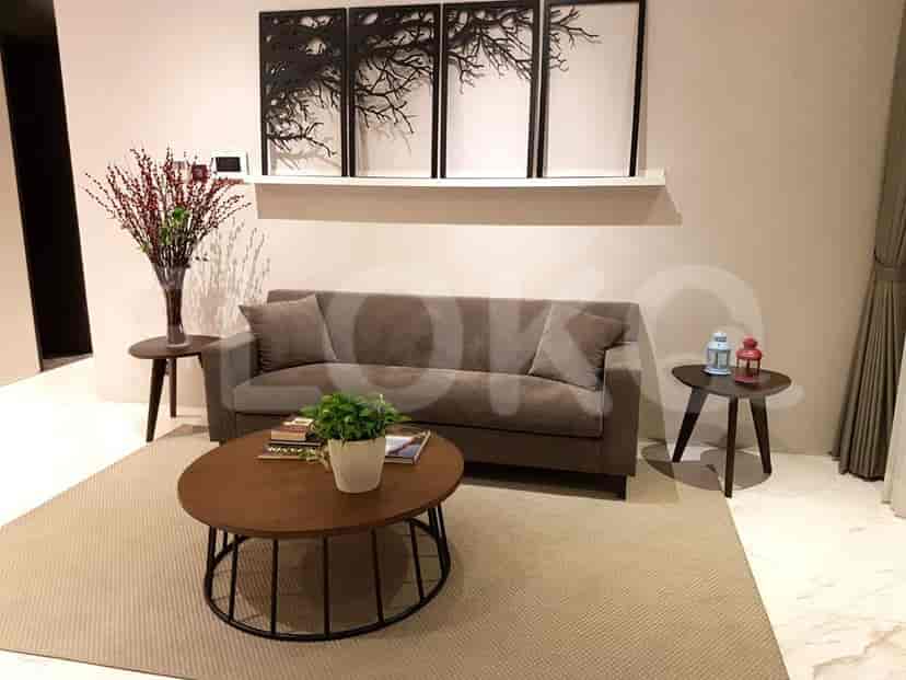 Modern living room with a grey sofa, artwork, and side tables.