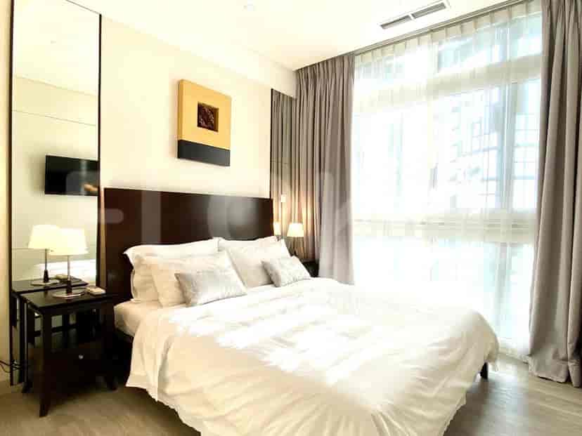 A modern bedroom with a king-size bed, a dark wooden headboard, and a large window.