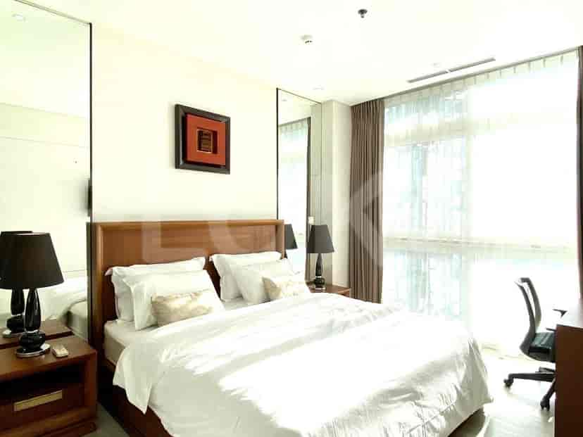 Another bedroom view with a king-size bed, large mirrors, and a work desk.