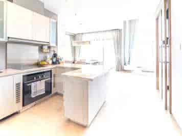 A modern kitchen with a white island, countertop, and open concept.