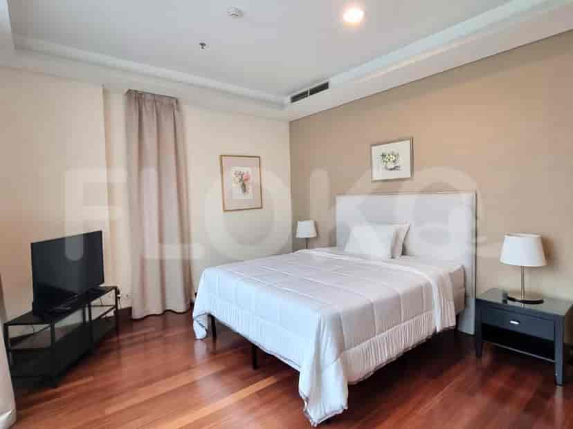 Bedroom with a bed, tv, and side table.