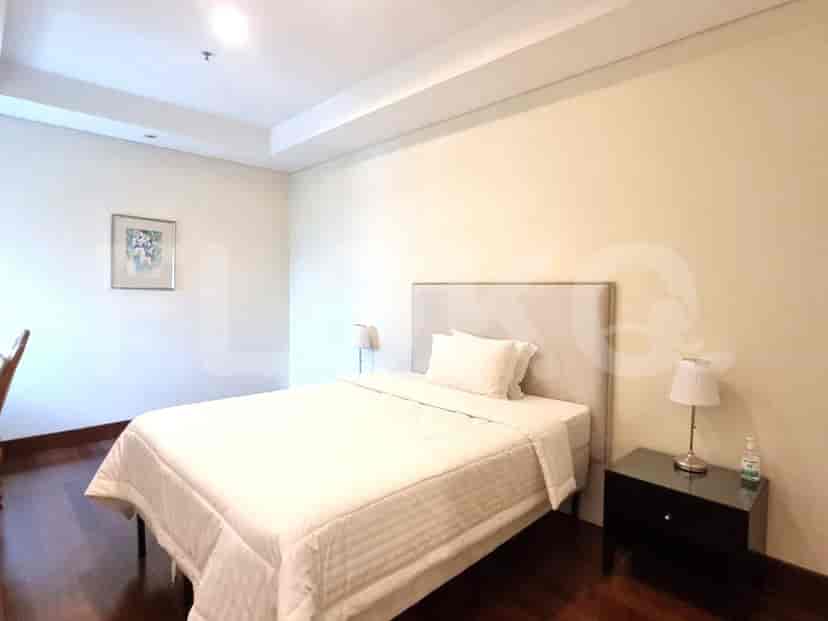 Bedroom with a bed, bedside table and artwork.