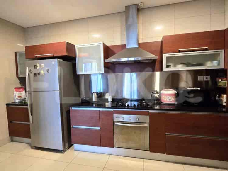 Modern kitchen with wooden cabinets, stainless steel appliances, and a black countertop.